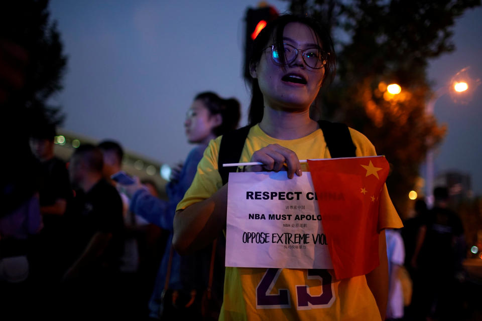 A woman holds a sign demanding NBA's apology outside the Mercedes-Benz Arena before the NBA exhibition game between Brooklyn Nets and Los Angeles Lakers in Shanghai. (Reuters)