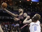 Chicago Bulls' Carlos Boozer (5) drives past Charlotte Bobcats' Bismack Biyombo (0) during the second half of an NBA basketball game in Charlotte, N.C., Wednesday, April 16, 2014. The Bobcats won 91-86 in overtime. (AP Photo/Chuck Burton)