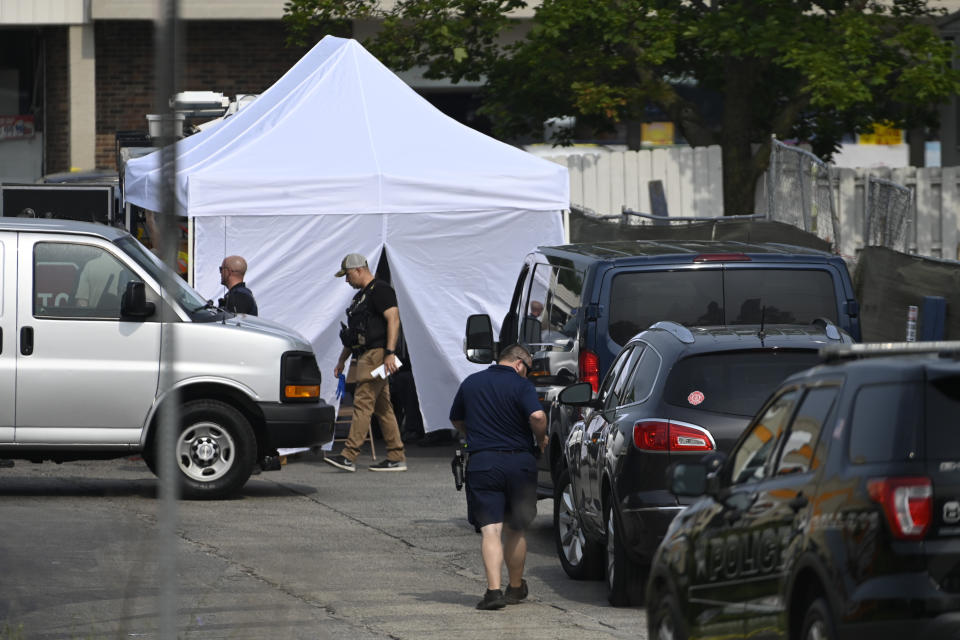 Investigators look over the scene of an overnight mass shooting at a strip mall in Willowbrook, Ill., Sunday, June 18, 2023. (AP Photo/Matt Marton)