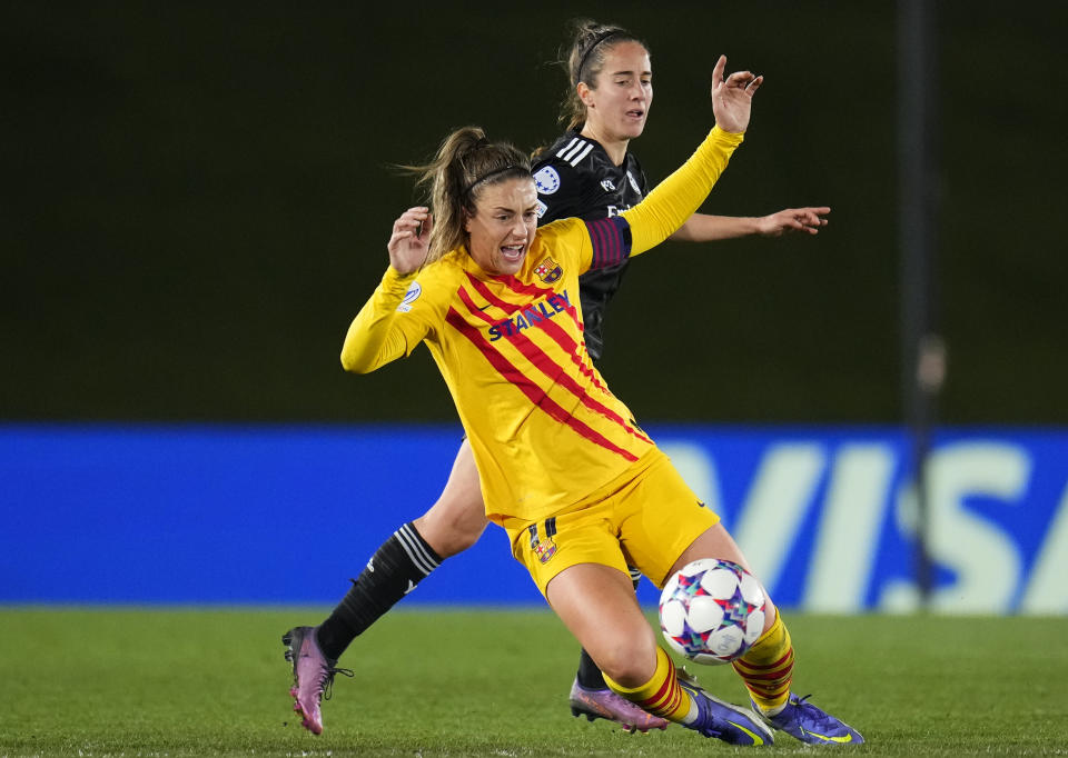 FILE - Barcelona's Alexia Putellas, front, duels for the ball with Real Madrid's Maite Oroz during the Women's Champions League quarter final, first leg soccer match between Real Madrid and Barcelona at Alfredo Di Stefano Stadium in Madrid, Spain, Tuesday, March 22, 2022. (AP Photo/Manu Fernandez, File)