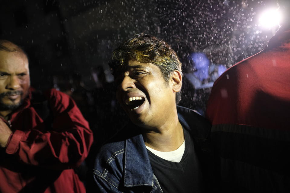 A man cries near a burning passenger train at Gopibagh in Dhaka, Bangladesh, Friday, Jan. 5, 2024. A fire on a moving passenger train in Bangladesh's capital on Friday night left at least four people dead and several others injured, ahead of Sunday's parliamentary election. (AP Photo/Mahmud Hossain Opu)