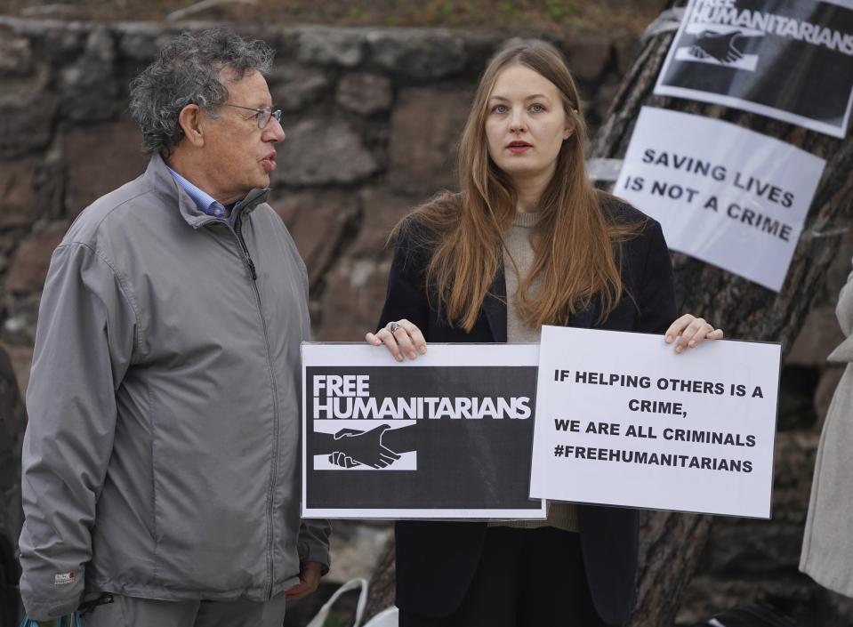 Pieter Wittenberg, left, one of 24 aid workers and volunteers accused of participating in migrant rescue operations, speaks with a protester outside a court in Mytilene, on the northeastern Aegean island of Lesbos, Greece, Friday, Jan. 13, 2023. The trial of 24 Greek and foreign aid workers and volunteers who participated in migrant rescue operations has resumed on an eastern Greek island, in a prosecution that has drawn widespread criticism from international human rights groups. (AP Photo/Panagiotis Balaskas)