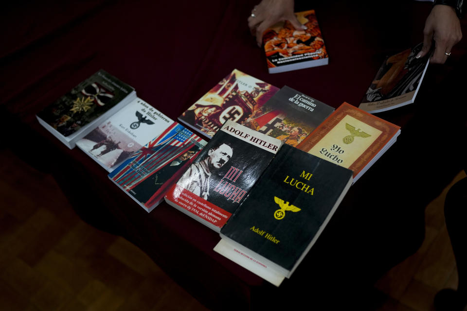 A federal police officer puts seized books back inside boxes after displaying them to the press at Federal Police headquarters in Buenos Aires, Argentina, Wednesday, Sept. 13, 2023. Law enforcement officers say the books were printed by what they describe as the biggest manufacturer of Nazi propaganda in Argentina after carrying out raids this week, following a two year investigation to shut down the illegal printing press and arrest its operator. (AP Photo/Natacha Pisarenko)