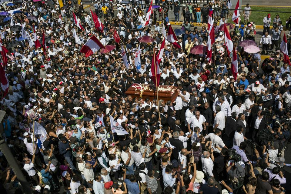 People carry the coffin of Peru's late President Alan Garcia through the street during his funeral procession in Lima, Peru, Friday, April 19, 2019. Garcia shot himself in the head and died Wednesday as officers waited to arrest him in a massive graft probe that has put the country's most prominent politicians behind bars and provoked a reckoning over corruption. (AP Photo/Rodrigo Abd)