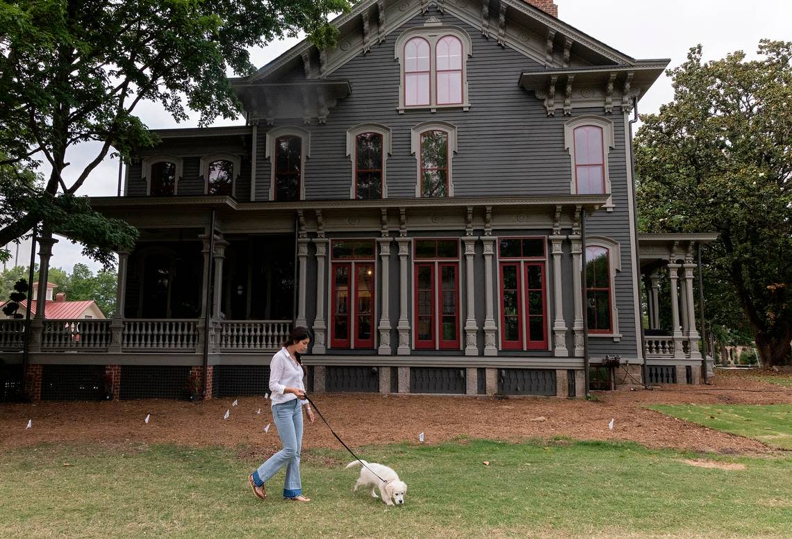 Tina Konidaris walks with Clementine, her family’s English Cream Golden Retriever puppy, outside the Andrews-Duncan House on May 25, 2023, in Raleigh. Konidaris and her partner, Jeff Turpin, moved into the nineteenth-century house in February after working to renovate it for about five years.