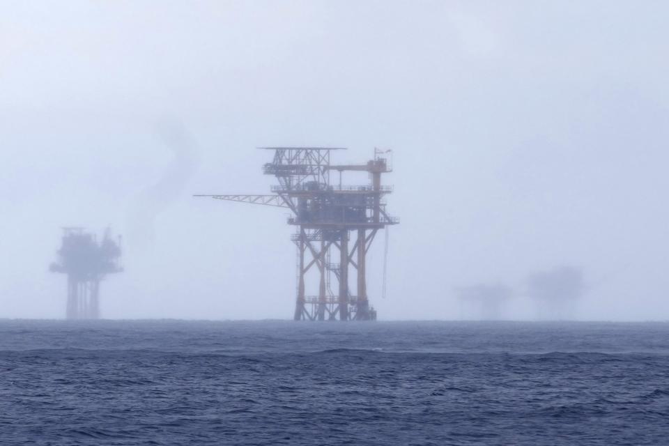 Oil platforms are visible through the haze near the Flower Garden Banks National Marine Sanctuary in the Gulf of Mexico, off the coast of Galveston, Texas, Saturday, Sept. 16, 2023. (AP Photo/LM Otero)