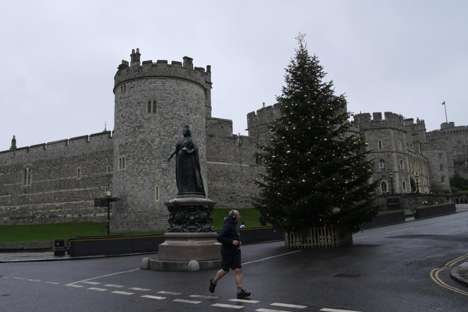 A jogger runs past Windsor Castle at Windsor on Christmas Day, Saturday, Dec. 25, 2021. Britain's Queen Elizabeth II has stayed at Windsor Castle instead of spending Christmas at her Sandringham estate due to the ongoing COVID-19 pandemic. (AP Photo/Alastair Grant)