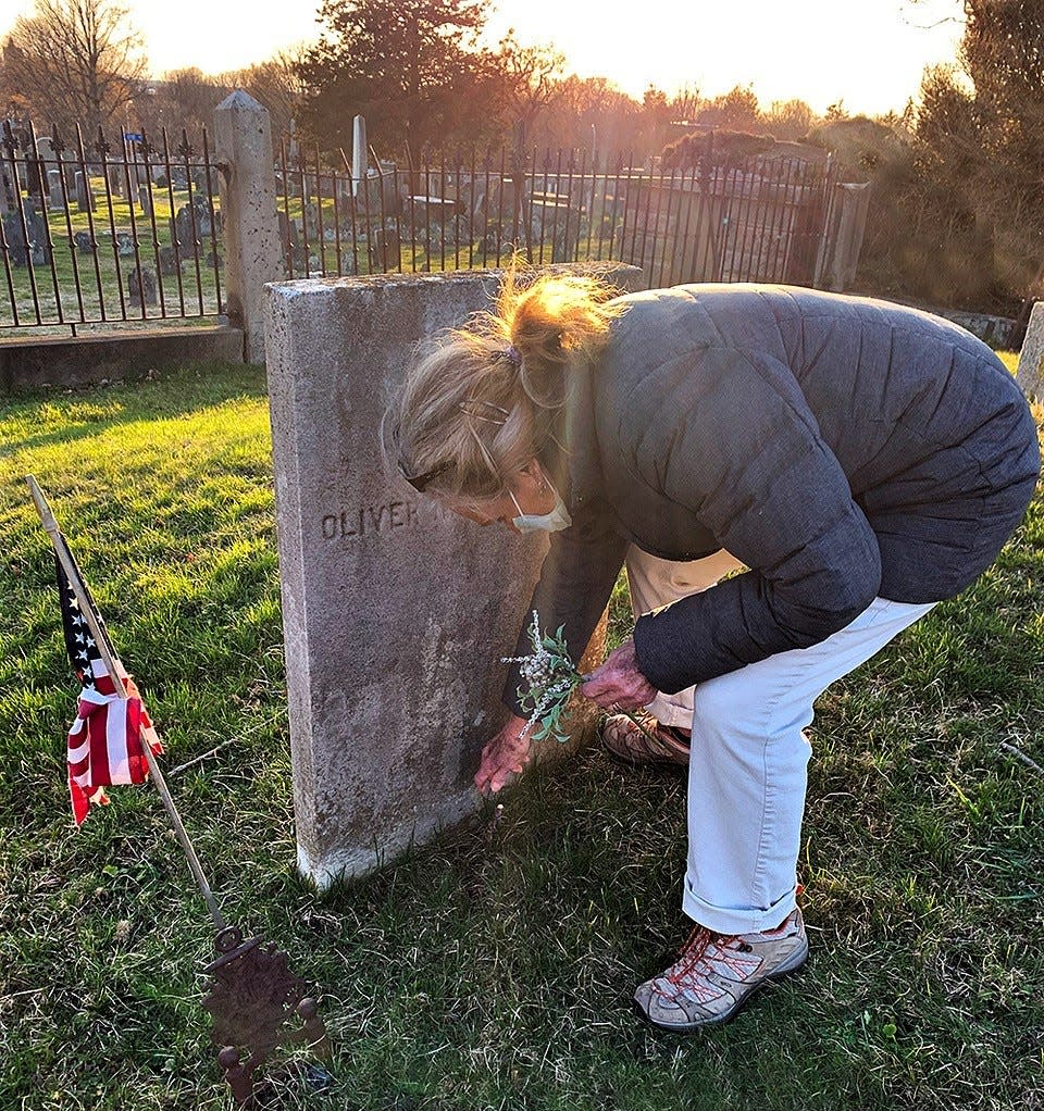 Stephanie Ocko placing a floral offering at the grave of American Naval War Hero Oliver Hazard Perry in Newport, RI in 2021.