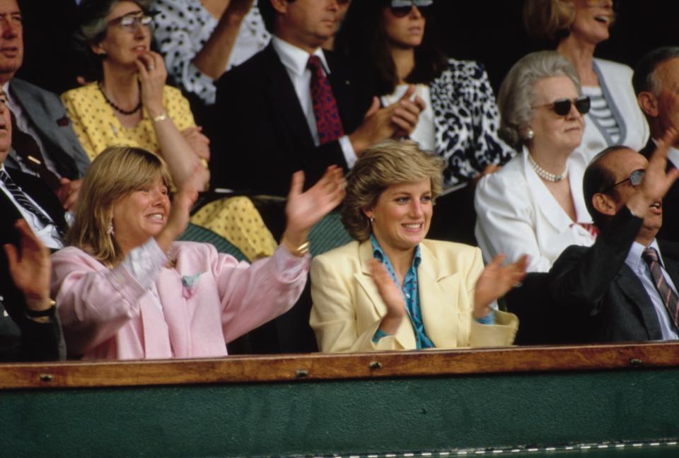 View of Diana, Princess of Wales (1961 - 1997) (fore center, in yellow jacket) as she applauds during a women's tennis match at Wimbledon, London, England, July 1987. (Photo by Derek Hudson/Getty Images)