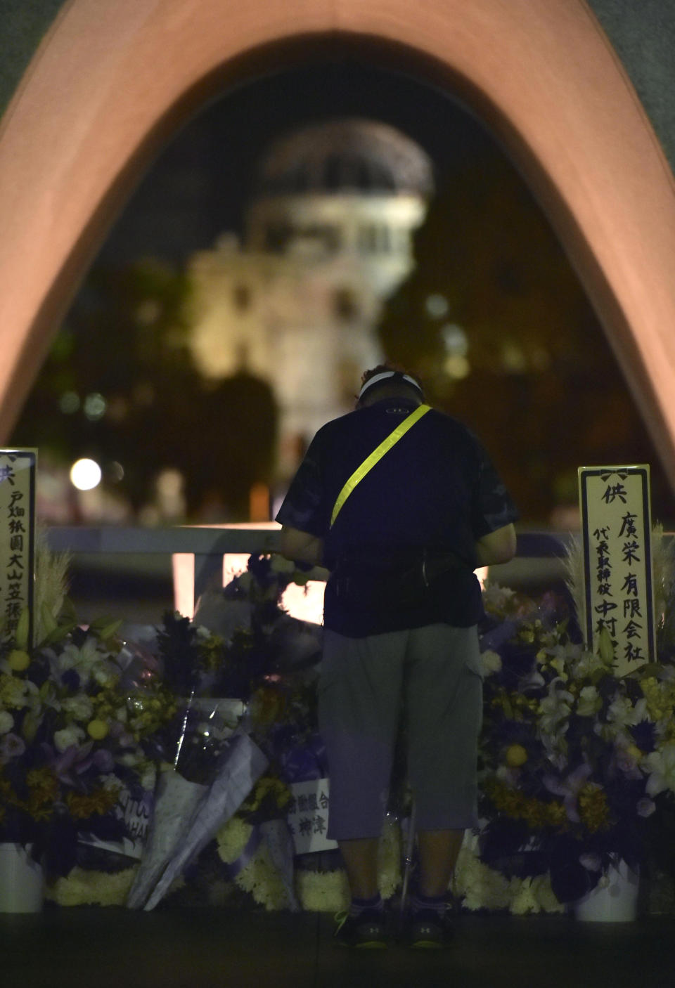 A man prays in front of the cenotaph dedicated to the victims of atomic bombing at Hiroshima Peace Memorial Park in Hiroshima, western Japan, Monday, Aug. 6, 2018, marking the 73rd anniversary of the bombing. Atomic Bomb Dome is seen in the background. (Shingo Nishizume/Kyodo News via AP)