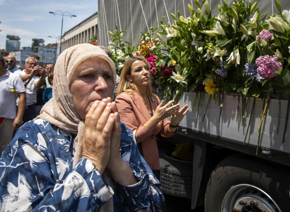 Women pay their respect next to the vehicle carrying the remains of 33 victims of the Srebrenica massacre, in Sarajevo, Bosnia, Tuesday, July 9, 2019. The remains will be buried in Potocari near Srebrenica, on July 11, 2019, 24 years after Serb troops overran the eastern Bosnian Muslim enclave of Srebrenica and executed some 8,000 Muslim men and boys, which international courts have labeled as an act of genocide (AP Photo/Darko Bandic)