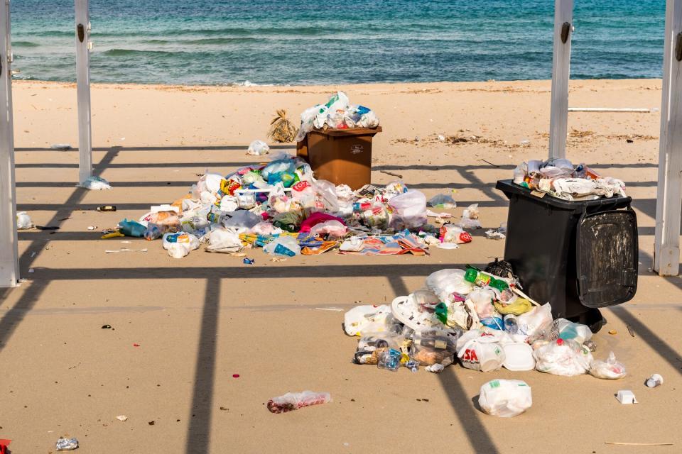 Containers with garbage on the sand at the Isola delle Femmine in Sicily.