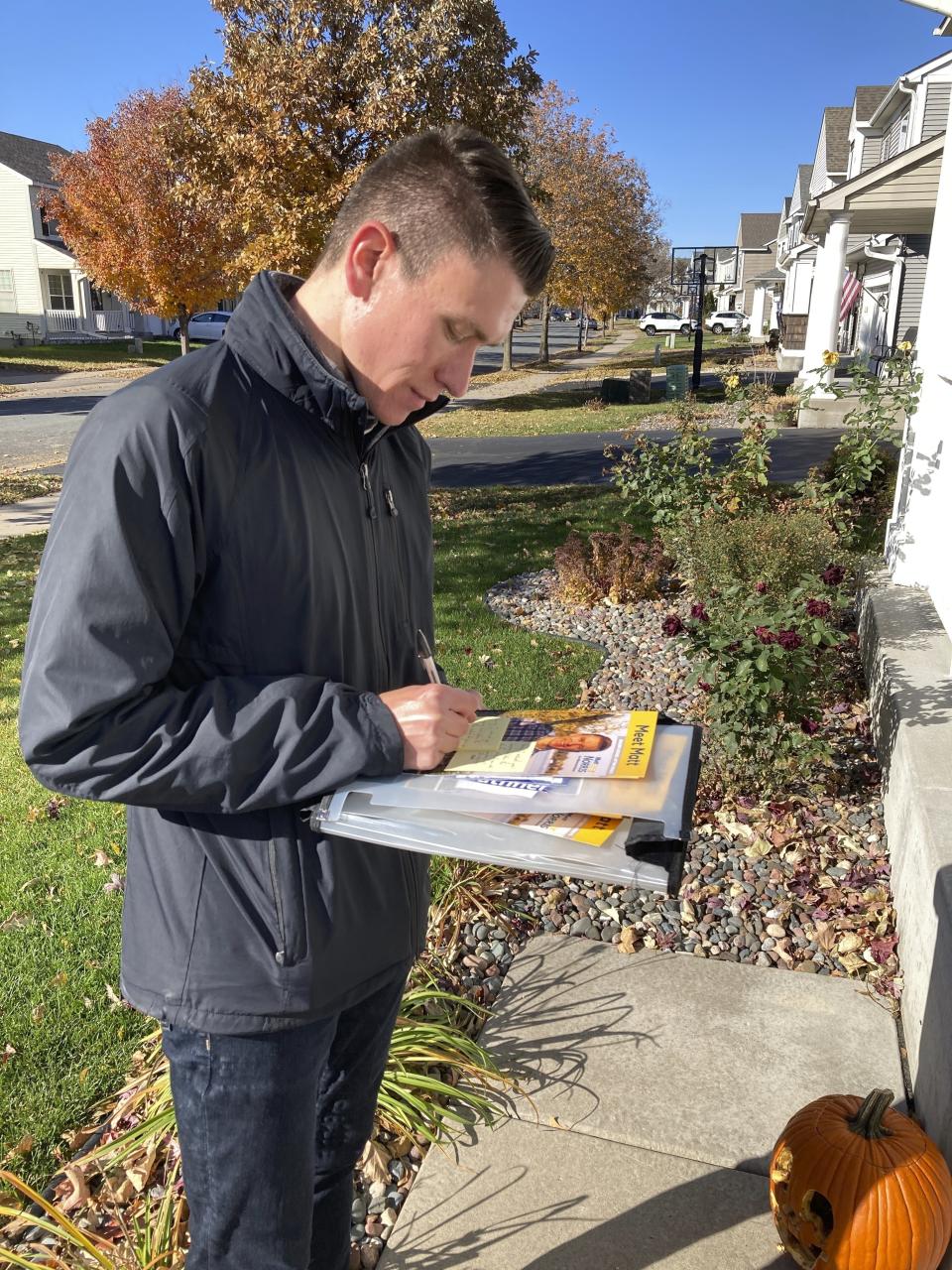 Matt Norris, a Democratic candidate for the Minnesota House, knocks on doors to seek votes in Blaine, Minn., on Wednesday, Oct. 26, 2022. (AP Photo/Steve Karnowski)