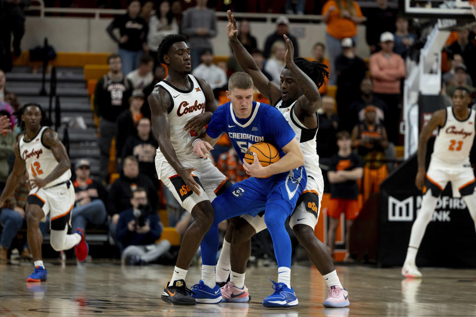 Oklahoma State forward Eric Dailey Jr., left, and guard Jamyron Keller, right guard Creighton guard Baylor Scheierman in the second half of an NCAA college basketball game, Thursday, Nov. 30, 2023, in Stillwater, Okla. (AP Photo/Mitch Alcala)