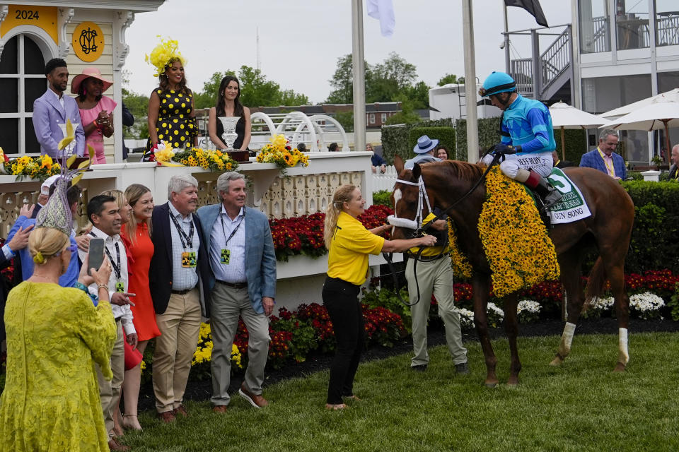 Baltimore Mayor Brandon Scott, top left, and Maryland first lady Dawn Moore, third from top left, look on as John Velazquez, atop Gun Song, celebrate in the winner's circle after winning the Black-Eyed Susan horse race at Pimlico Race Course, Friday, May 17, 2024, in Baltimore. (AP Photo/Julia Nikhinson)