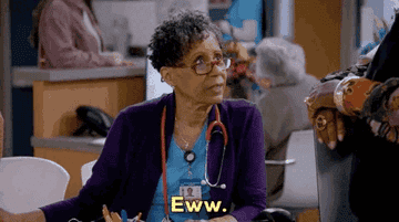 An older woman with curly hair at a desk reacts with disgust, saying "Eww," while wearing a stethoscope and looking at someone off-camera