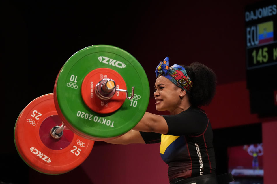 Neisi Patricia Dajomes Barrera of Ecuador lowers the barbell after her final lift, in the women's 76kg weightlifting event, at the 2020 Summer Olympics, Sunday, Aug. 1, 2021, in Tokyo, Japan. (AP Photo/Luca Bruno)