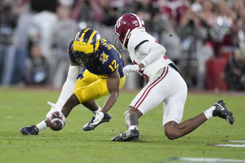 Michigan defensive back Josh Wallace (12) recovers a fumble by Alabama quarterback Jalen Milroe (4) during the second half in the Rose Bowl CFP NCAA semifinal college football game Monday, Jan. 1, 2024, in Pasadena, Calif. (AP Photo/Mark J. Terrill)