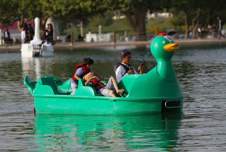 Boys ride a boat at Aspire Park in Doha, Qatar April 8, 2016. REUTERS/Naseem Zeitoon