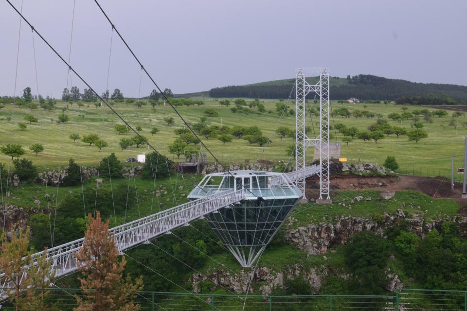 a glass bridge and diamond-shaped bar in the middle, suspended over the Dashbashi Canyon in Georgia