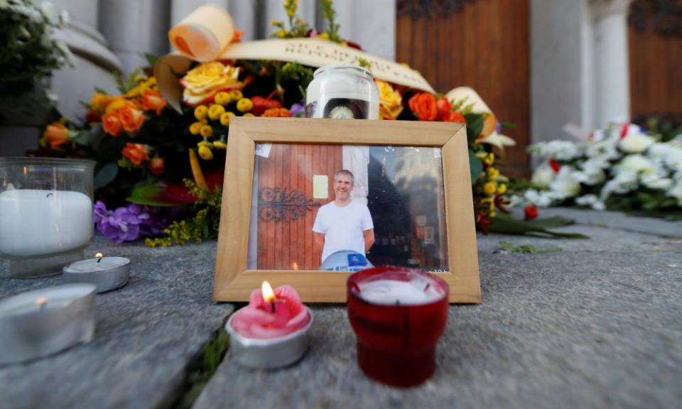A picture of Vincent Loquès is seen among candles and flowers in front of Notre Dame basilica