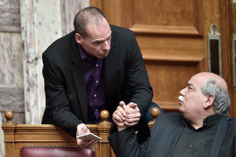 Nikos Voutsis (right) speaks with Greek Finance Minister Yanis on March 18, 2015 in parliament in Athens