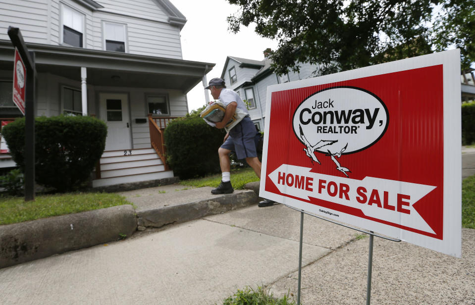 A mailman delivers mail to a house for sale in Quincy, Mass.