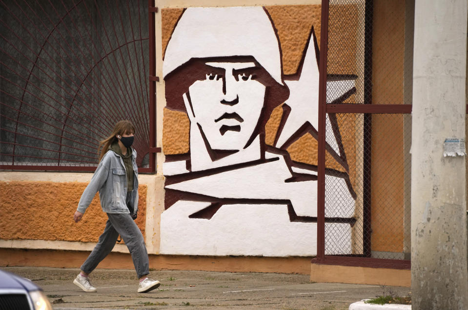 FILE - A woman walks past the Operational Group of Russian Forces headquarters in Tiraspol, the capital of the Russia-backed breakaway region of Transnistria, in Moldova, Nov. 1, 2021. Since Russia fully invaded Ukraine two years ago, a string of incidents in Transnistria have periodically raised the specter that European Union candidate Moldova could also be in Moscow's crosshairs. (AP Photo/Dmitri Lovetsky, File)