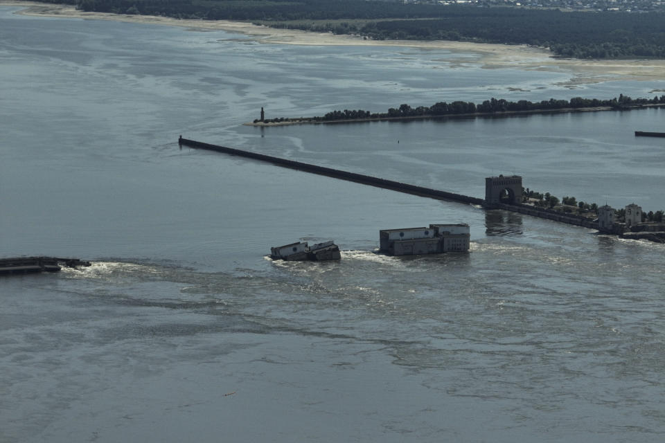 Un torrente de agua fluye por encima de la derrumbada represa de Kajovka, en Nova Kajovka, en territorio ucraniano ocupado por Rusia, el 7 de junio de 2023. (AP Foto)