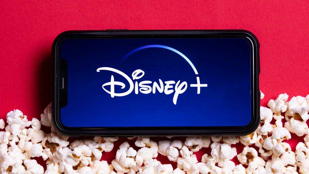  The Disney Plus logo on a phone surrounded by popcorn. 