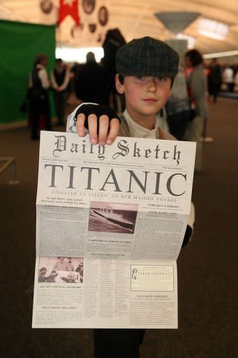 This handout photo released by the Titanic Memorial Cruises shows a child posing with a memorial newspaper in the departure lounge of the MS Balmoral cruise ship in Southampton on April 8. Passengers then plan to throw wreaths into the sea at 2:20 am about 800 kilometers (500 miles) southeast of Halifax at the time and place the ship sank