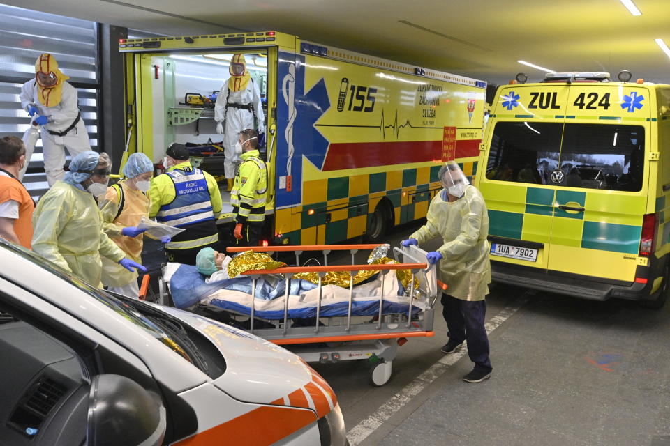 Health workers at the Motol University Hospital carry one of the patients with COVID-19, who was transported to Prague from a hospital in Brno, Czech Republic, Thursday, Nov. 25, 2021. COVID spread reaches another record in Czech Republic, with 27,717 new confirmed COVID cases on Thursday, another daily maximum since the start of the epidemic. (Vit Simanek / CTK via AP)