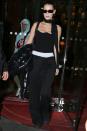 <p>Leaving her hotel in Paris in a strapless Versace bustier top, black slouchy wide-legged pants, a skinny scarf, and sunglasses.</p>