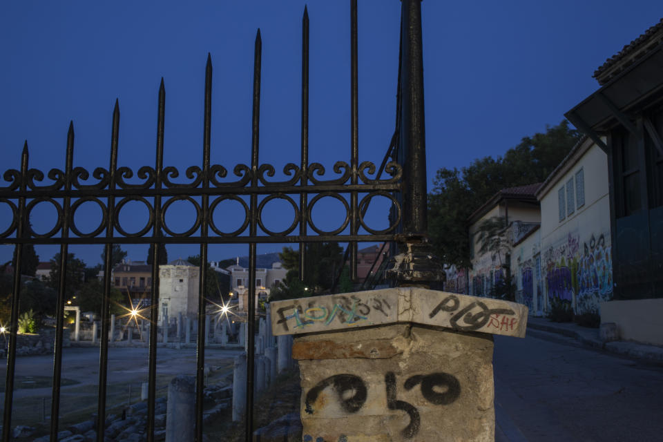 In this Monday, July 22, 2019 photo, a fence and buildings are covered with graffiti outside the ancient Roman agora in Plaka district of Athens. (AP Photo/Petros Giannakouris)