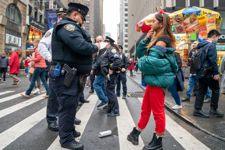 A person receives a citation for public drinking from an NYPD officer during SantaCon in New York City. (Photo by David Dee Delgado/Getty Images)