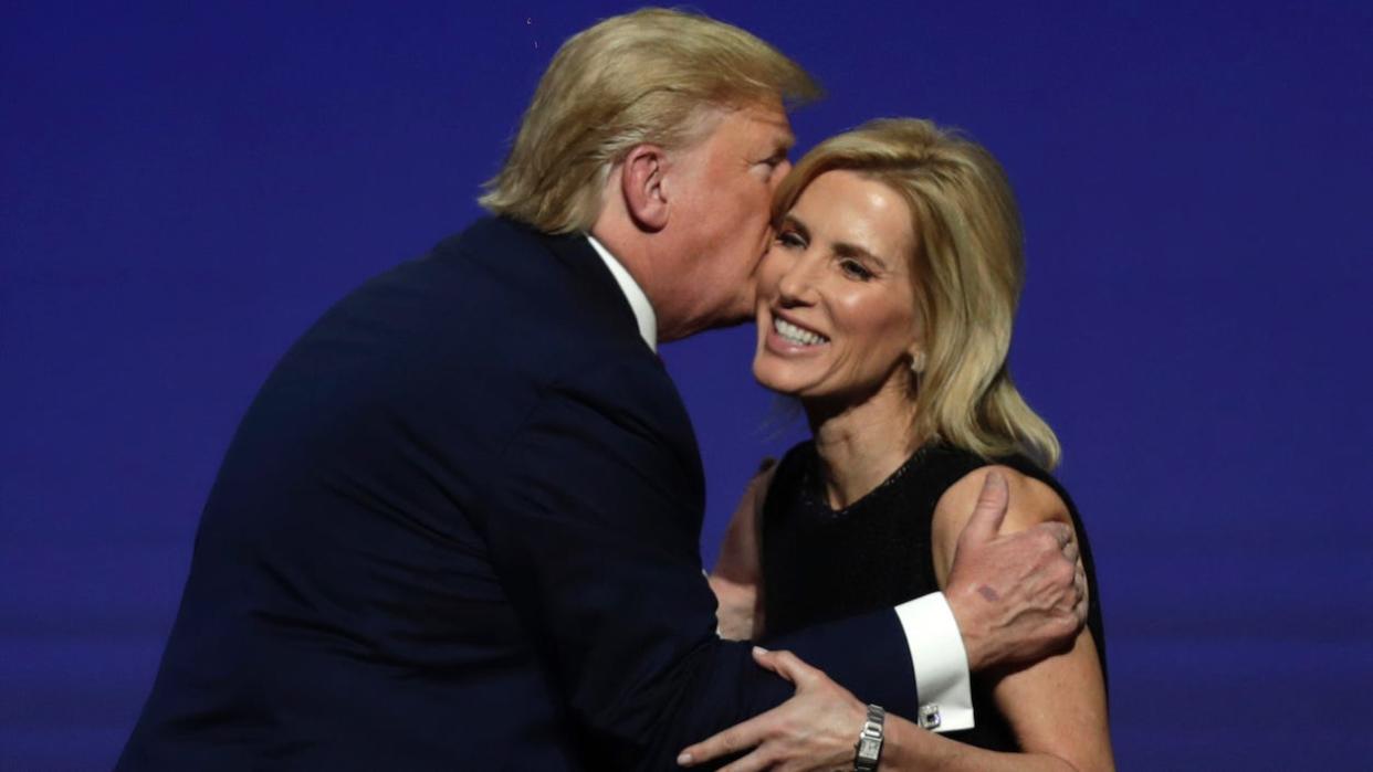 President Donald Trump gives Laura Ingraham a kiss after inviting her on stage during the Turning Point USA Student Action Summit at the Palm Beach County Convention Center, Saturday, Dec. 21, 2019, in West Palm Beach, Fla.