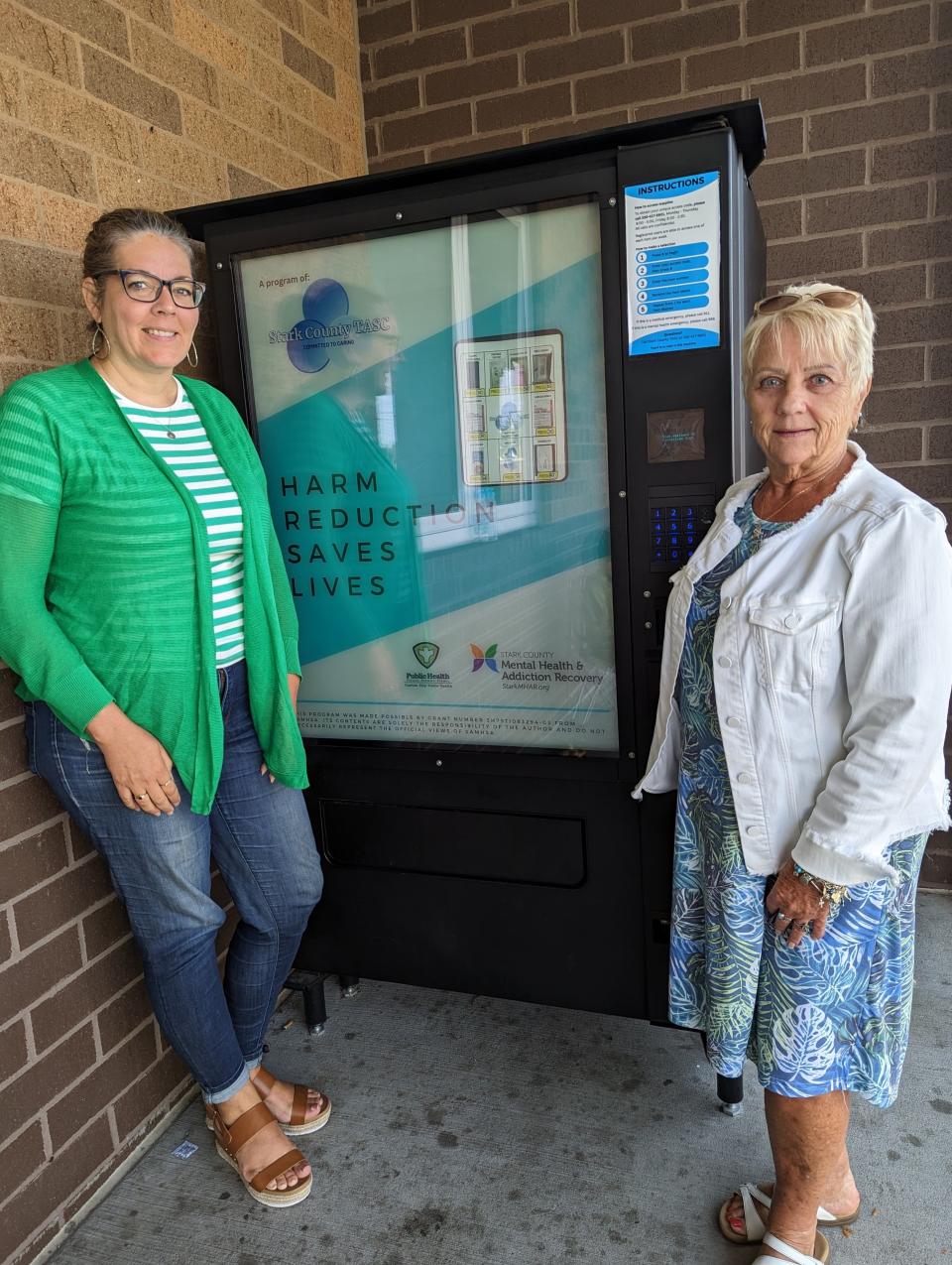 Kristie Woods (left) and Jo Ann Carpenter of Refuge of Hope Ministries in Canton stand next to a "Harm Reduction Supply Machine," a self-serve vending machine installed in April which distributes free supplies and information for people struggling with substance abuse. The machine is an part of  of a harm-reduction outreach by Stark Mental Health & Addiction Recovery.