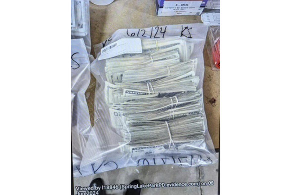 This photo supplied by the U.S. Attorney's Office for Minnesota shows cash from a bag that was left at the home of a juror in a massive fraud case, June 2, 2024, outside Minneapolis, Minn. Authorities have confiscated cellphones and taken all seven defendants into custody as investigators try to determine who attempted to bribe the juror to acquit them on charges of stealing more than $40 million from a program meant to feed children during the pandemic. (U.S. Attorney's Office for Minnesota via AP)