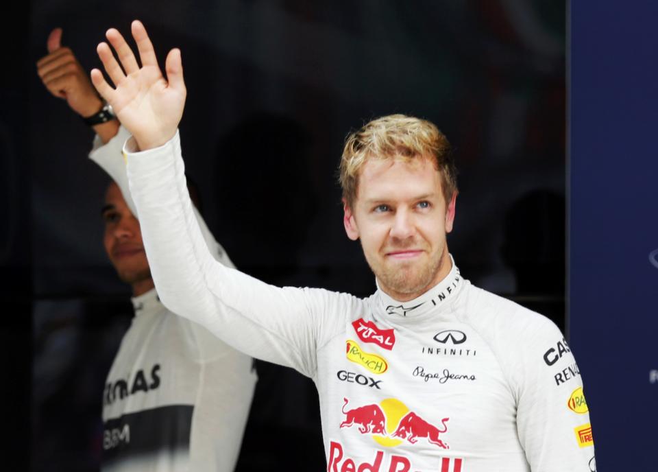 Red Bull Formula One driver Sebastian Vettel of Germany (R) and Mercedes Formula One driver Lewis Hamilton of Britain gesture after the qualifying session of the Indian F1 Grand Prix at the Buddh International Circuit in Greater Noida, on the outskirts of New Delhi, October 26, 2013. REUTERS/Ahmad Masood (INDIA - Tags: SPORT MOTORSPORT F1)