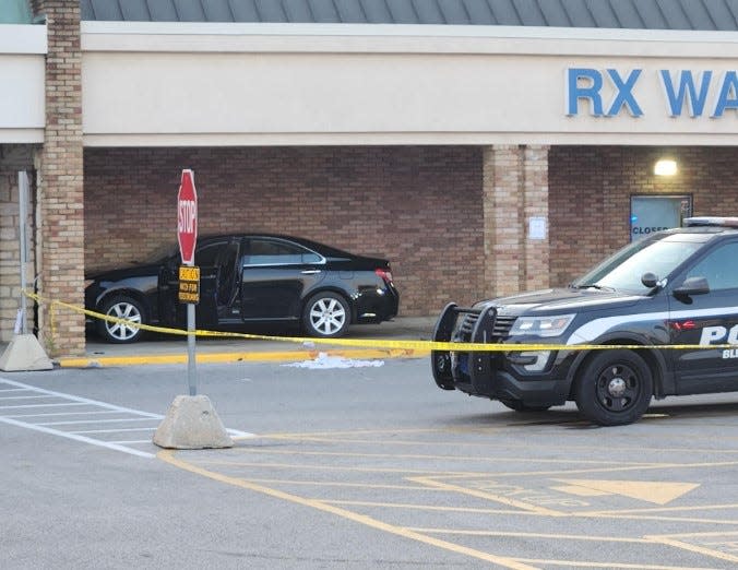 The driver's side door is open on a four-door sedan reportedly involved in a shooting incident Thursday evening, Aug. 23, 2023, involving a Blendon Township police officer in the parking lot of the Kroger store at 5911 Sunbury Road, just north of Route 16, near Westerville. The car apparently went over the curb of a sidewalk outside the grocery store's walk-up pharmacy window and appears to have struck an exterior wall and/or column.