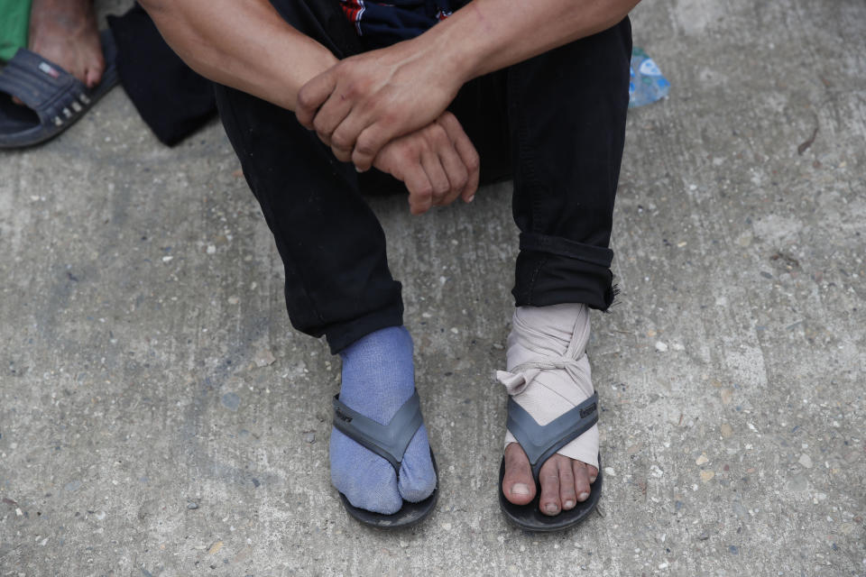 A Honduran migrant with a bandaged foot awaits medical attention from Guatemalan Red Cross paramedics before he is deported after the group he was traveling with was stopped by police in Morales, Guatemala, Thursday, Jan. 16, 2020. Less-organized migrants, tighter immigration control by Guatemalan authorities and the presence of U.S. advisers have reduced the likelihood that the hundreds of migrants who departed Honduras will form anything like the cohesive procession the term “caravan” now conjures. (AP Photo/Moises Castillo)