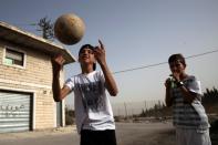 Children play with a soccer ball in the Palestinian village of Sur Baher, which sits on either side of an Israeli military barrier in East Jerusalem and the Israeli-occupied West Bank