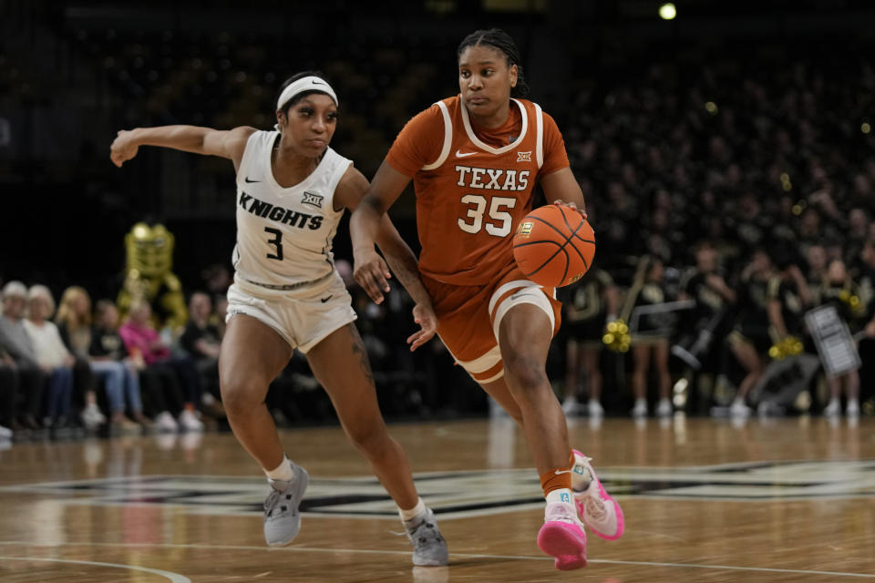 Texas forward Madison Booker (35) drives past Central Florida guard Kaitlin Peterson (3) during the second half of an NCAA college basketball game, Saturday, Feb. 24, 2024, in Orlando, Fla. (AP Photo/John Raoux)