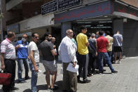 People line up outside an exchange shop to buy U.S. dollars, in Beirut, Lebanon, June 17, 2020. Lebanon's financial meltdown has thrown its people into a frantic search for dollars as the local currency's value evaporates. Long, raucous lines mass outside exchange bureaus to buy rationed dollars. Many try to rescue their dollars trapped in bank accounts frozen by the government. With tens of thousands thrown into poverty, the turmoil is fueling bitterness at banks and politicians. (AP Photo/Hussein Malla)