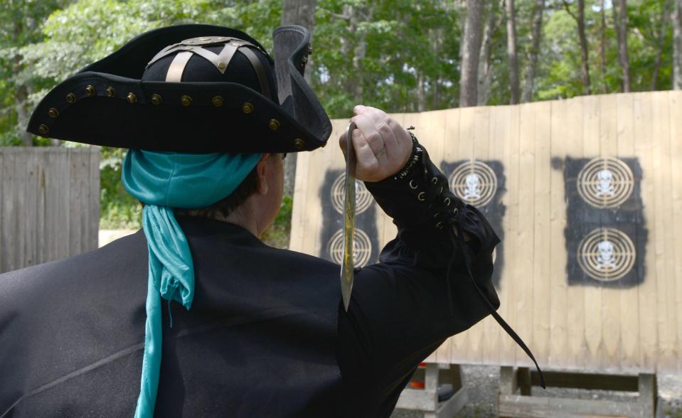 Dressed for the part, Sarah Lareau takes aim at the knife throwing targets on the first day of the 2021 Pirate Festival. Steve Heaslip/Cape Cod Times