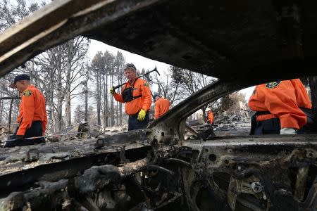 Ed Lim (L), Mitch Rogers and fellow search and rescue personnel inspect the aftermath of the Tubbs Fire in the Coffey Park neighborhood of Santa Rosa, California U.S., October 17, 2017. REUTERS/Loren Elliott