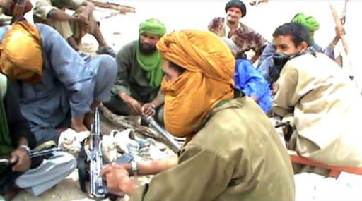 A still from a video shows Islamist militants sitting on the ground with their weapons after destroying an ancient shrine in Timbuktu on July 1. The Islamists controlling northern Mali on Tuesday destroyed two tombs at the ancient Djingareyber mosque in fabled Timbuktu, vowing to destroy all World Heritage sites in the region