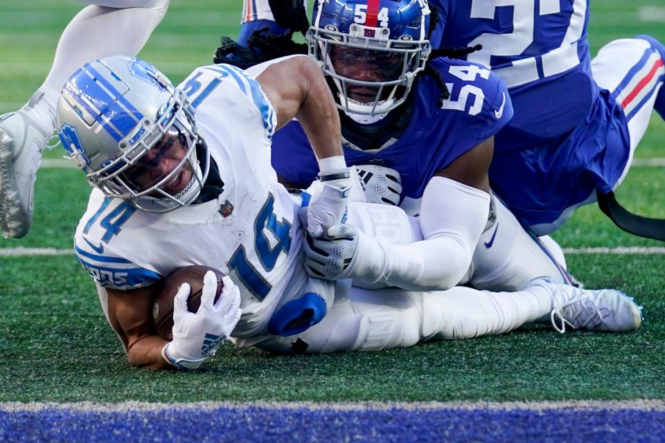 El receptor abierto de los Detroit Lions, Amon-Ra St. Brown (14), es abordado por el apoyador de los New York Giants, Jaylon Smith (54), durante la segunda mitad, el 20 de noviembre de 2022, en East Rutherford, Nueva Jersey.