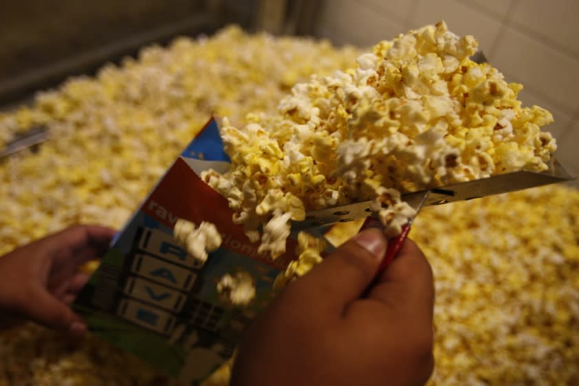 Schaben, Allen J. –– B581148611Z.1 LOS ANGELES, CA – MARCH 21, 2011: A concession worker scoops up popcorn at Rave 18 (formerly The Bridge) at The Promenade at Howard Hughes Center in Westchester. The nation's cinema operators are upset about the FDA's proposed rules that would require theaters to disclose the calorie count of their concessions––including popcorn. (Allen J. Schaben / Los Angeles Times)