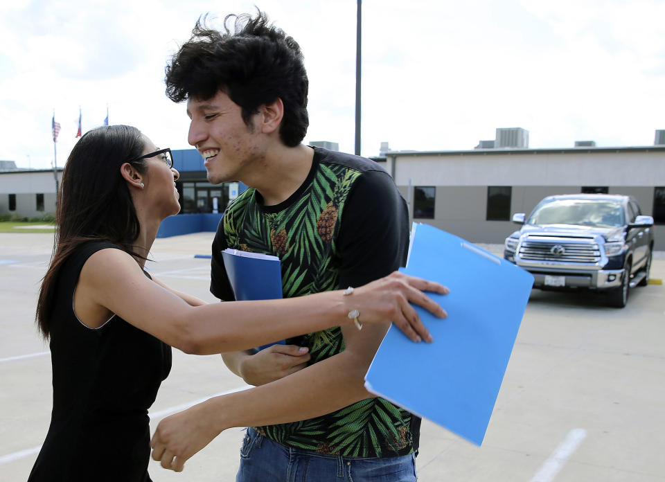 U.S. citizen Francisco Galicia, 18, gets a hug from his attorney, Claudia Galan, after his release from the South Texas Detention Facility in Pearsall, Texas, Tuesday, July 23, 2019. Galicia was released from immigration custody Tuesday after wrongfully being detained for more than three weeks. Galicia lives in the border city of Edinburg, Texas, and was traveling north with a group of friends when they were stopped at a Border Patrol inland checkpoint. According to Galan and the Dallas Morning News, agents apprehended Galicia on suspicion that he was in the U.S. illegally even though he had a Texas state ID. (Kin Man Hui/The San Antonio Express-News via AP)